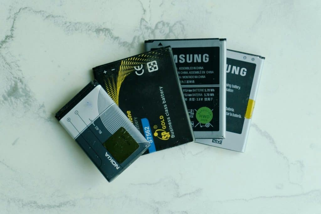 Several old mobile phone batteries on a white surface